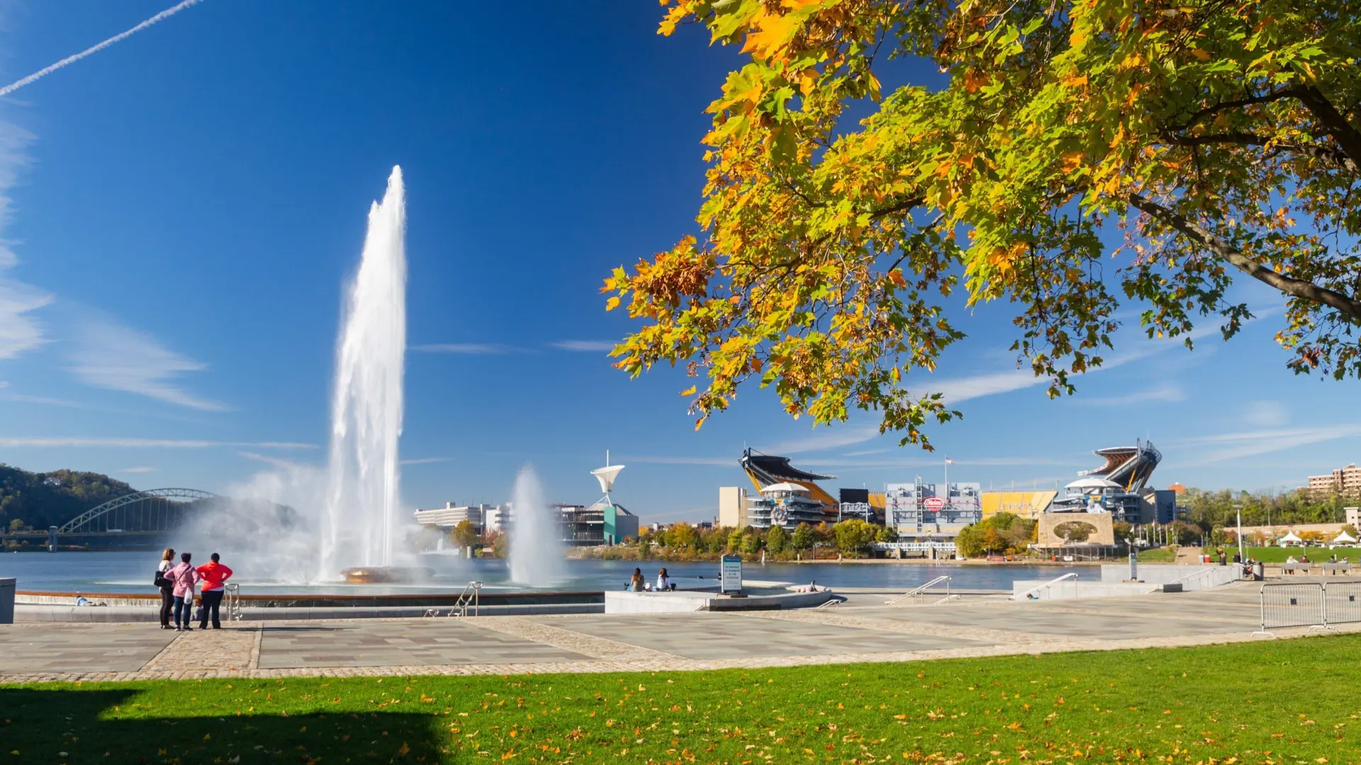 The fountain at Point State Park with the Pittsburgh riverfront and stadium beyond in autumn